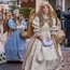 Donne in costumi da angelo dorati e blu durante una sfilata
