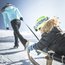 Bambino con casco verde viene trainato su una slitta attraverso un paesaggio innevato